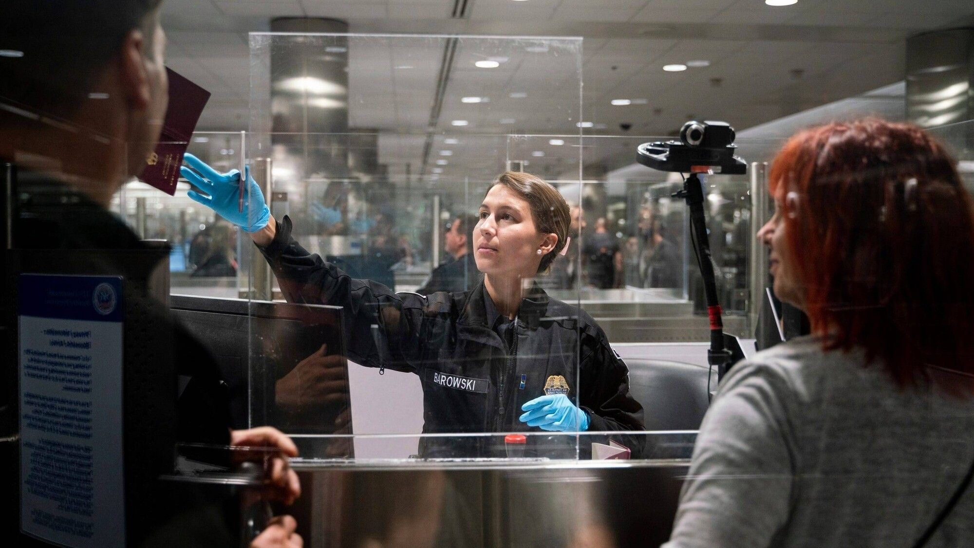 Syndication: Detroit Free Press CBP officer G. Barowski, center, screens international travelers Henning Radtke, left, a